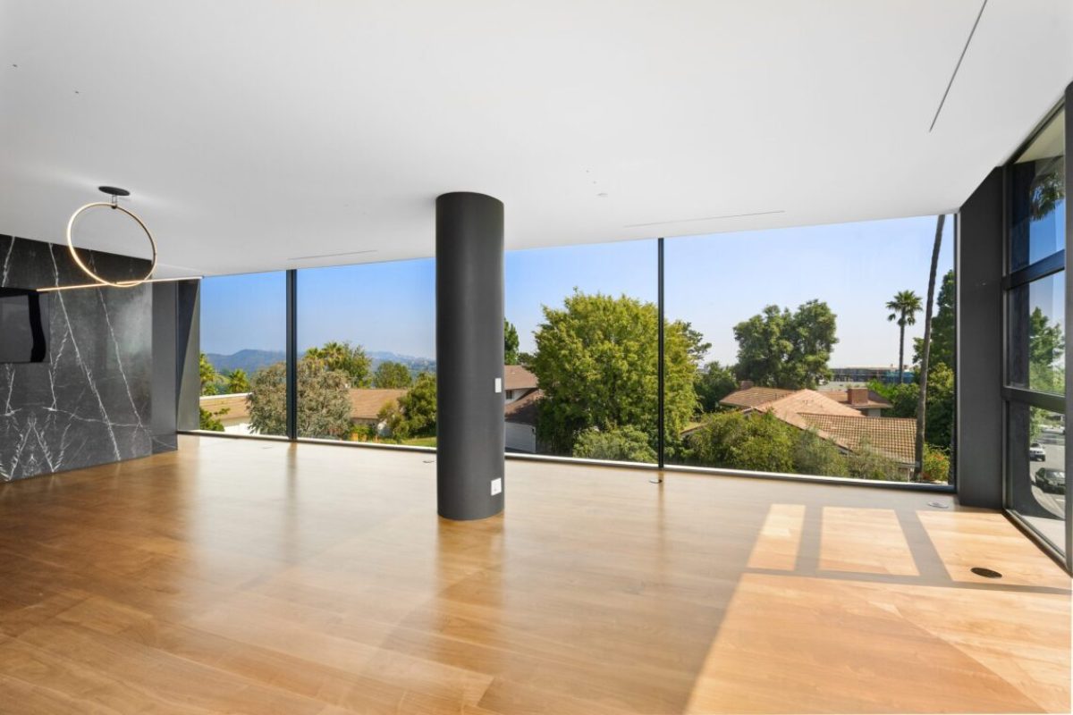 Spacious room with large glass window showcasing scenic mountain and tree views