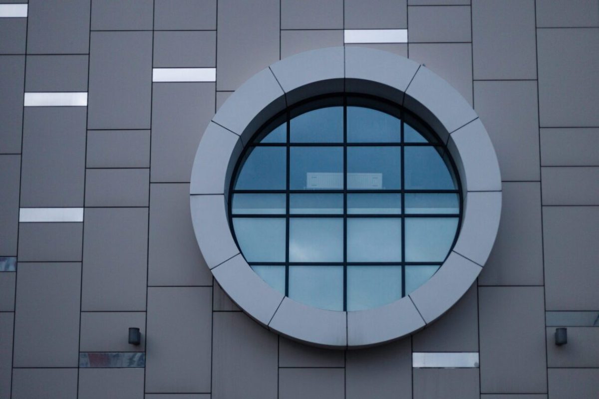 A big rounf window on a modern gray building