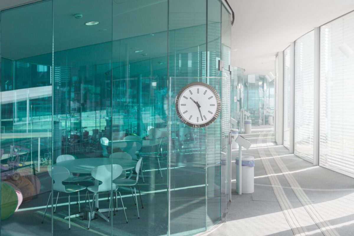 Design of modern office with blue transparent walls and light hallway with clock, Switzerland