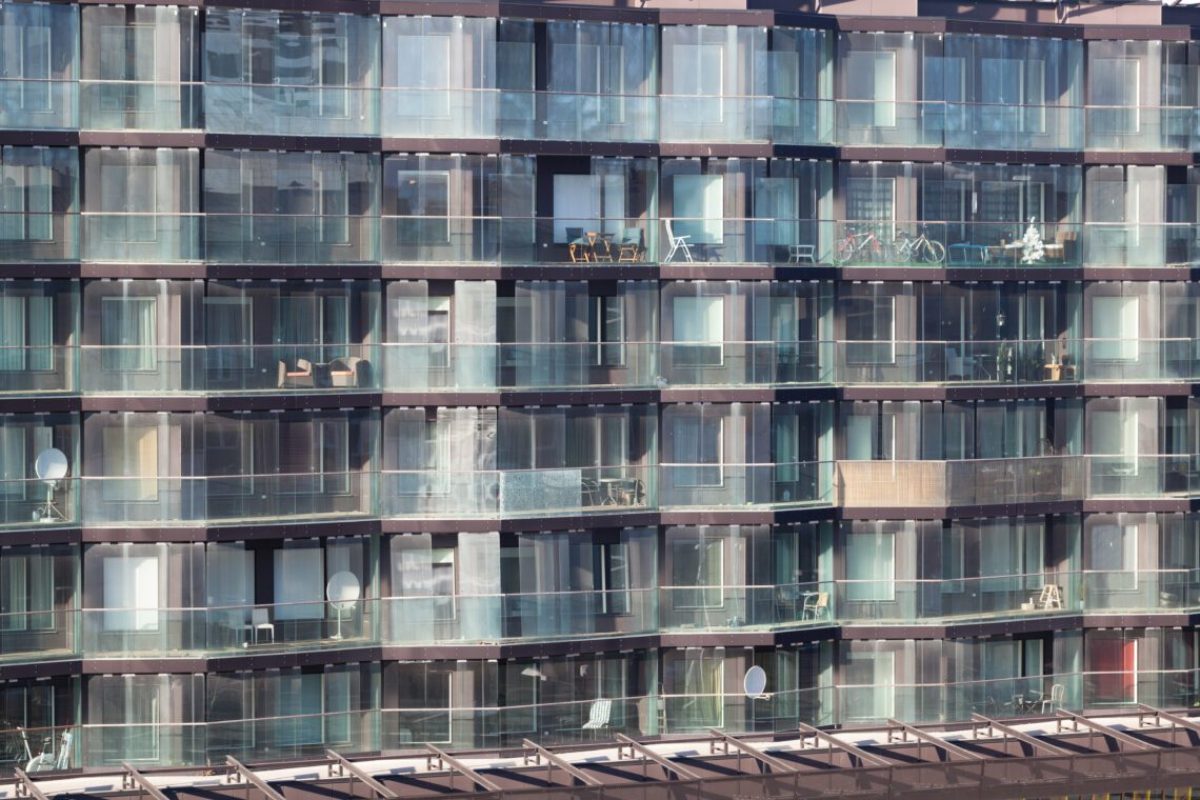 Architectural background of the exterior of a modern apartment block with large glass windows and balconies in an example of high density living