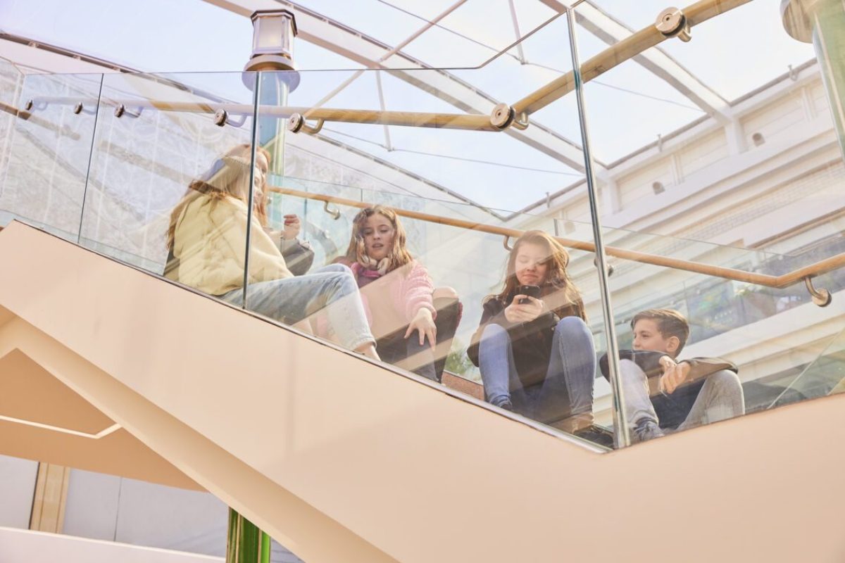Friends hanging out on a modern glass staircase.