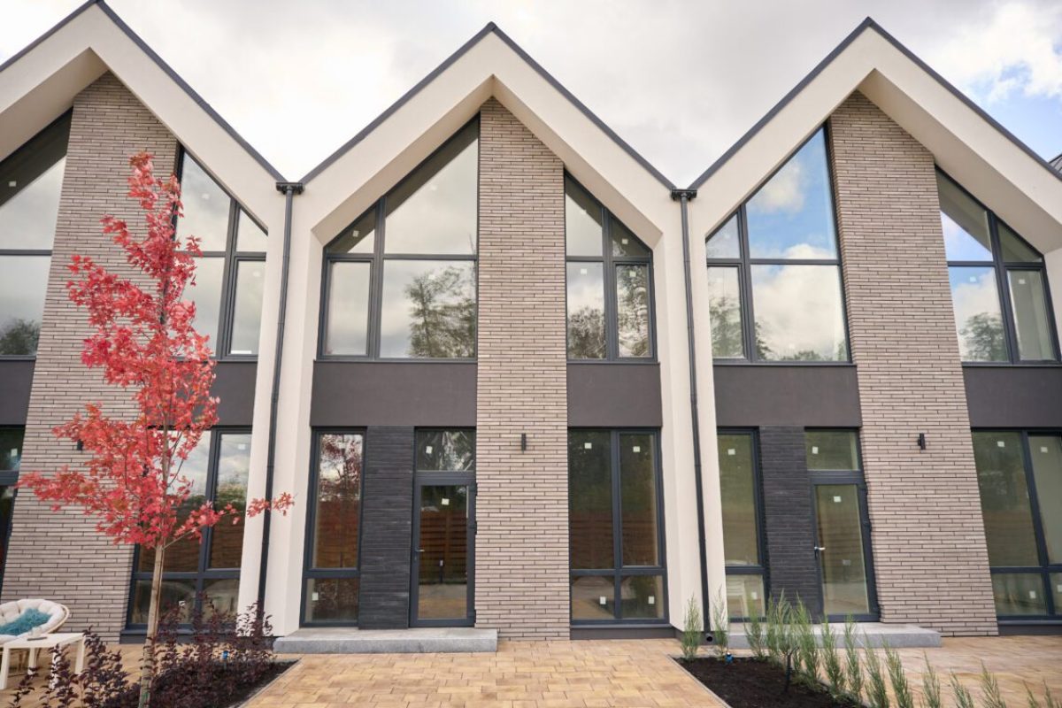 Facades of attractive two storey contemporary houses standing in a row in suburban area
