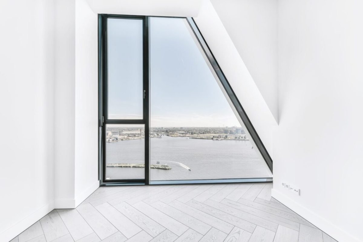 Unfurnished room interior with parquet flooring and white walls and wall window in luxury apartment