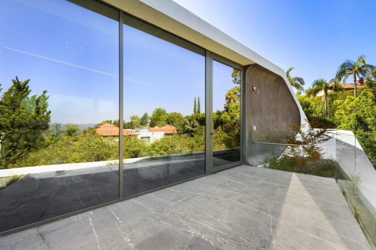 A Modern balcony with transparent glass walls offering a view of the exterior