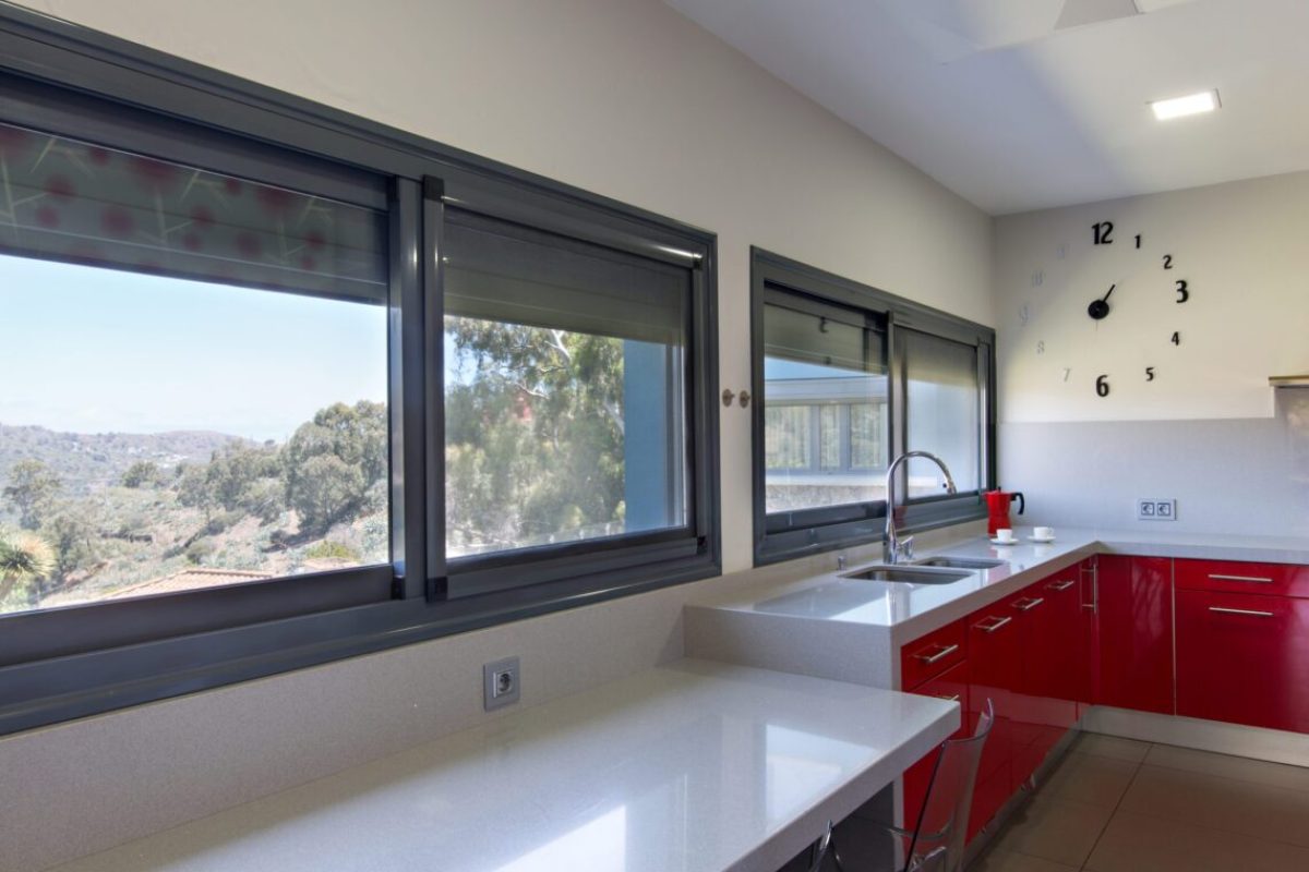 modern kitchen in red, with exterior view. Interior design of house.
