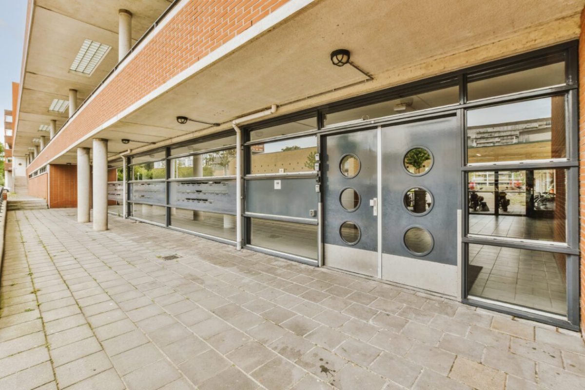 Panorama view of brick houses from an empty sidewalk street with cars, trees and lanterns