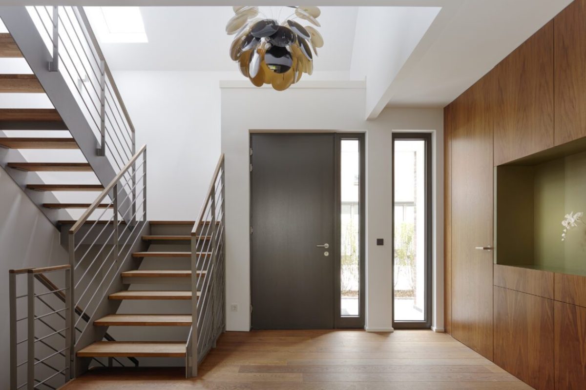 Plank floor and walnut wall covering in home near staircase