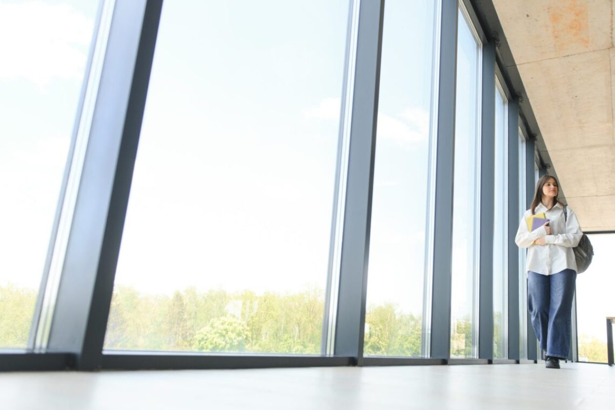 Portrait of a schoolgirl at school. She holds books in her hands. Education concept